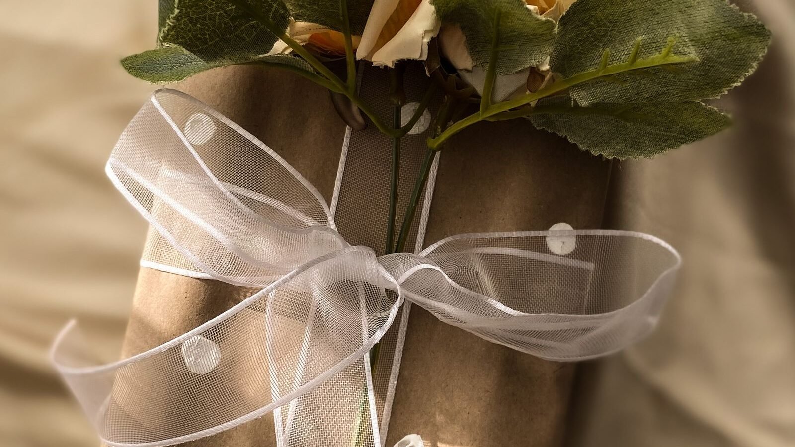 Fresh flowers tied on top of a wrapped gift box