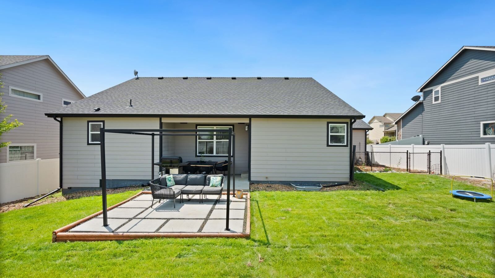 Small backyard patio with outdoor seating beside a house